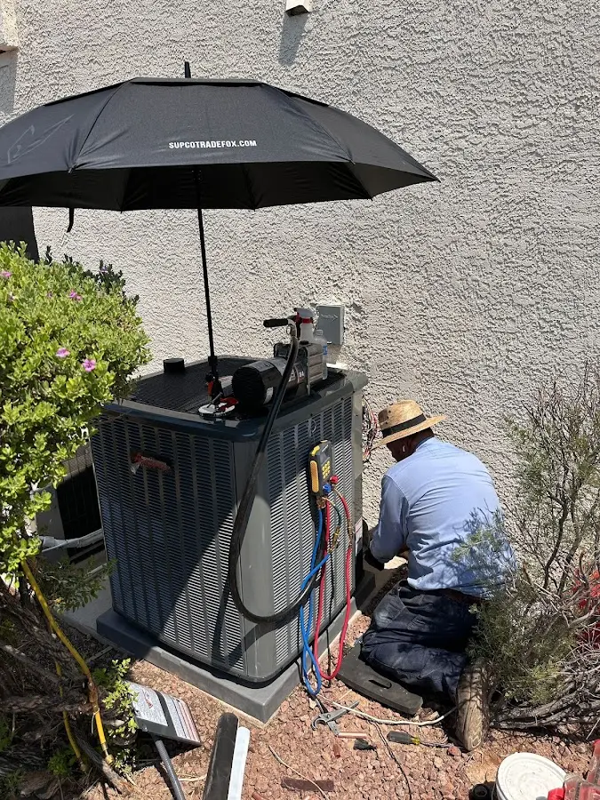 HVAC technician performing outdoor AC maintenance in Fairview