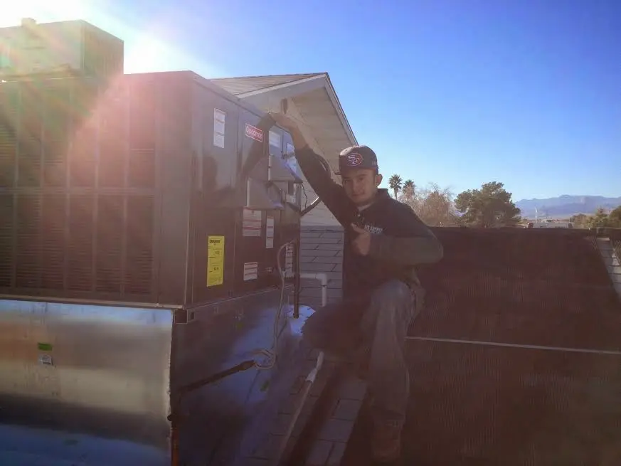 HVAC technician performing Boiler Repair on a rooftop unit in Fairview